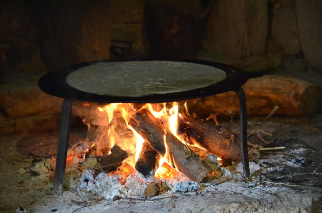 Backen von Galettes und Crêpes über dem Holzfeuer im Dorf Poul Fétan in der Bretagne (Frankreich)