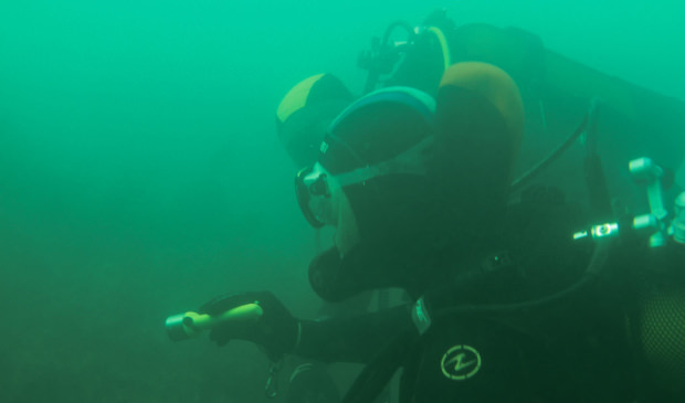 Musée sous-marin à Lorient La Base. Plongeurs sous l'eau, éclairant une épave.
